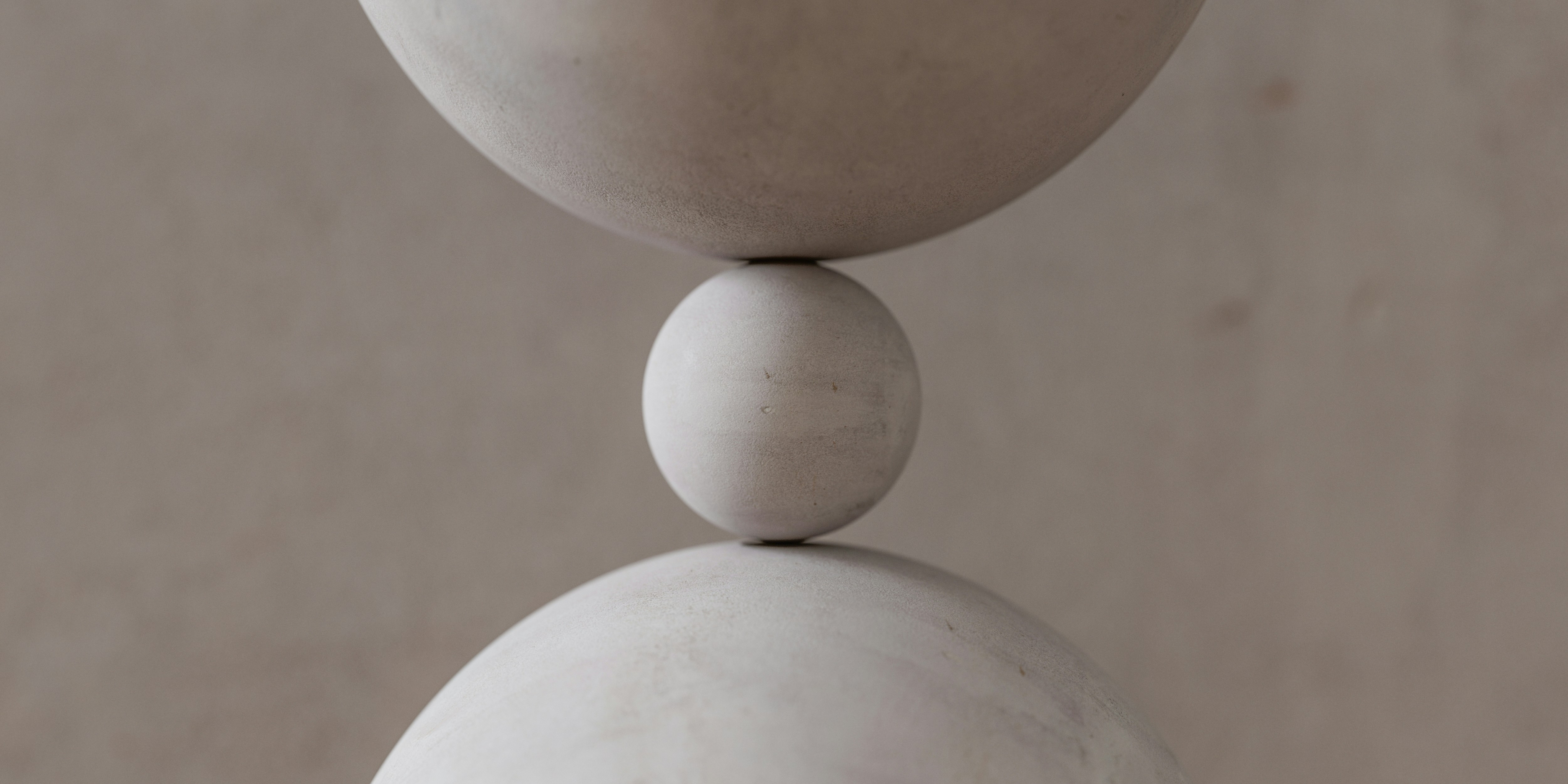 A image of a concrete sphere, balanced between two other larger spheres